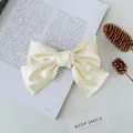 Elegant cream satin bow hair clip featuring a layered ribbon design for a vintage style - Off White