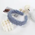 Detail of soft fuzzy blue headband on white textured fabric with aesthetic props - Gray