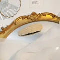 Elegante crèmekleurige gebreide haarklem op een vintage spiegel in romantische stijl - druppel / Druppel Gembergeel