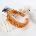 Close-up of caramel fleece headband texture with cozy white home decor accessories - Orange