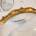 Stijlvolle witte gebreide haarspeld op een gouden vintage spiegel achtergrond - druppel / Traan Wit