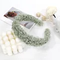 Detailed texture of a plush sage green lamb wool headband on a minimalist white backdrop - Light Green