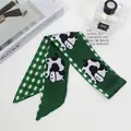 Detail of silk-like green scarf with cow print and check patterns on a clean desk - Green Cow