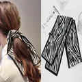 Detailed macro view of zebra print satin hair scarf featuring elegant black piping edges - Zebra Print