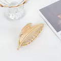 Dettaglio della pinza per capelli dorata a forma di foglia con trama metallica fine - Oro 18K