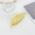 Dettaglio molletta per capelli dorata a forma di foglia con venature e finitura lucida - Oro opaco