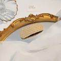 French vintage style cream woven hair clip placed on a gold decorative mirror - Square Ginger