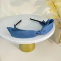 Detailansicht eines dunkelblauen Stoff-Haarreifens mit Schleife auf einem Display - Dunkelblau