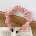 Roze geplooide stoffen hoofdband met golvende textuur en zwarte beschermkappen - Roze