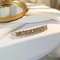 Detail of amber crystal hair clip with gold alloy base and white rhinestone accents - Dark Gray