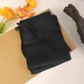 Detail of elegant black silk hair ribbon scarf with washing label on a natural background - Black