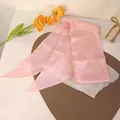 Détail d'un ruban à cheveux en satin rose cerise avec des pointes élégantes sur cuir - Rose