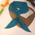 Macro view of a knotted teal silk-textured long scarf featuring elegant draping fabric - Green