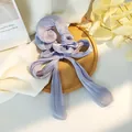 Dettaglio macro dell'elastico in raso lavanda con fiocco e lucentezza setosa del nastro - Viola