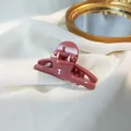 Detail of dusty rose hair claw clip on white fabric with a golden decorative mirror - Dusty Pink