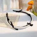 Detail van de Franse vintage hoofdband met dubbele parels en zwarte strikjes - Zwart