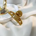 Close-up of a mustard yellow hair claw clip on a white textured fabric and gold tray - Green