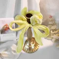Dettaglio di un elastico per capelli a fiocco in raso giallo tenue con trama setosa - Giallo chiaro