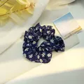 Vista dettagliata di un elastico per capelli blu navy a fiori su tessuto morbido - Margherita Blu Notte / Blu navy