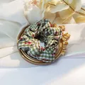 Detail of green gingham scrunchie with red cherry prints on decorative mirror - Green