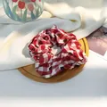 Detail van rood-witte ruitjes scrunchie op een houten dienblad met tulp decoratie - Rood