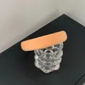 Detail of a thick padded sponge headband in apricot orange fabric on a glass cup - Orange