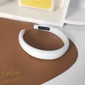 Detailaufnahme des cremefarbenen Polster-Stirnbands mit Hand Made Etikett und Köperstruktur - Weiß