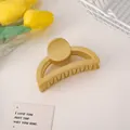 Primer plano de una pinza para el cabello semiredonda amarillo mate con peine de dientes - Amarillo