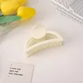 Matte cream semi-circle hair claw clip for women shown with decorative flowers - Off White