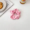 Primo piano di elastico a scacchi rosa e bianco con morbide pieghe in tessuto su sfondo decorativo - Elastico per capelli rosa
