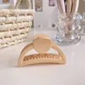 Detail of a cream-colored matte hair claw clip with strong teeth and elegant curved design - Light Coffee