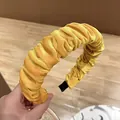 Detalle de diadema de terciopelo plisado amarillo con textura suave y puntas negras - Amarillo