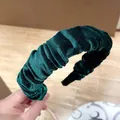 Detalle de la textura plisada y brillo del terciopelo verde en la diadema fina - Verde