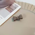 Elegante taupekleurige strik haarklem van hars met een glanzende afwerking - Koffie Haarclip