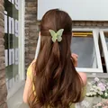 Pinza de mariposa verde claro mate en el cabello castaño ondulado de la modelo - Verde Hierba