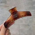 Pinza per capelli color ambra traslucida con elegante design curvo minimalista - Caramello