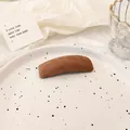 Minimalist brown suede sponge hair clip in rectangle shape on a ceramic plate - Brown