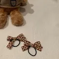 Paire de chouchous à nœuds à carreaux marron et blanc sur un tissu blanc texturé doux - Café