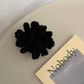 Close-up of black plush scrunchie with fluffy chenille texture on a minimal background - Black