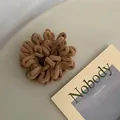 Close-up of thick plush brown scrunchie with soft chenille texture for winter hair styling - Khaki