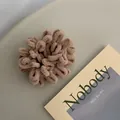 Close-up of soft light brown plush hair scrunchie on a minimalist grey desk setup - Light Coffee