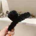 Close-up of black plush faux fur hair claw clip with soft texture for winter hairstyles - Black