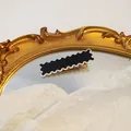 Black wavy hair clip with white scalloped edge on vintage gold mirror background - Black White Edge Wave