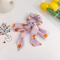 Lila Haargummi mit orangefarbenen Blumenmustern und eleganten Schleifenbändern - Lila