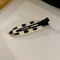 Minimalist black and white checkerboard pattern hair clip with a sleek flat oval shape - Black and Yellow Checkered