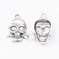 Vintage zinc alloy skull pendants with bone in mouth, showing front and back views - Antique Silver