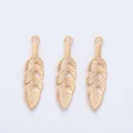 Detailed view of three vintage gold feather charms with intricate leaf vein textures - KC Gold