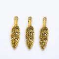 Detailed view of three vintage gold leaf feather charms for DIY jewelry making - Antique Gold
