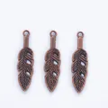 Detailed view of three vintage copper feather charms with realistic leaf textures for DIY - Red Bronze