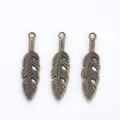 Three vintage bronze feather charms for DIY jewelry making with detailed leaf textures - Antique Bronze